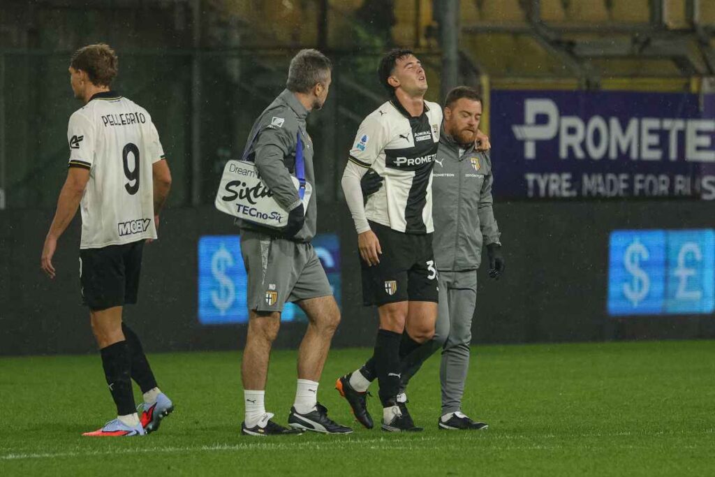 calciatore sorretto dallo staff medico