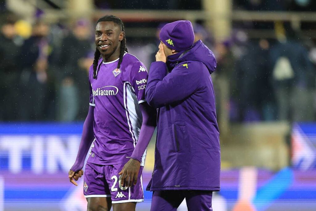 kean che sorride in campo con uno dello staff