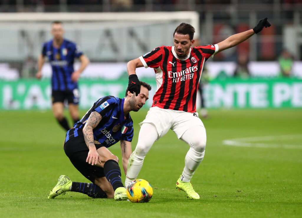 MILAN, ITALY - FEBRUARY 02: Ismael Bennacer of AC Milan is put under pressure by Hakan Calhanoglu
